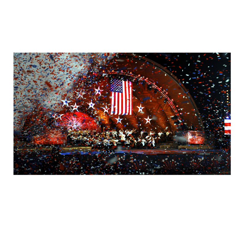Image of an orchestra on stage with the USA flag behind them.